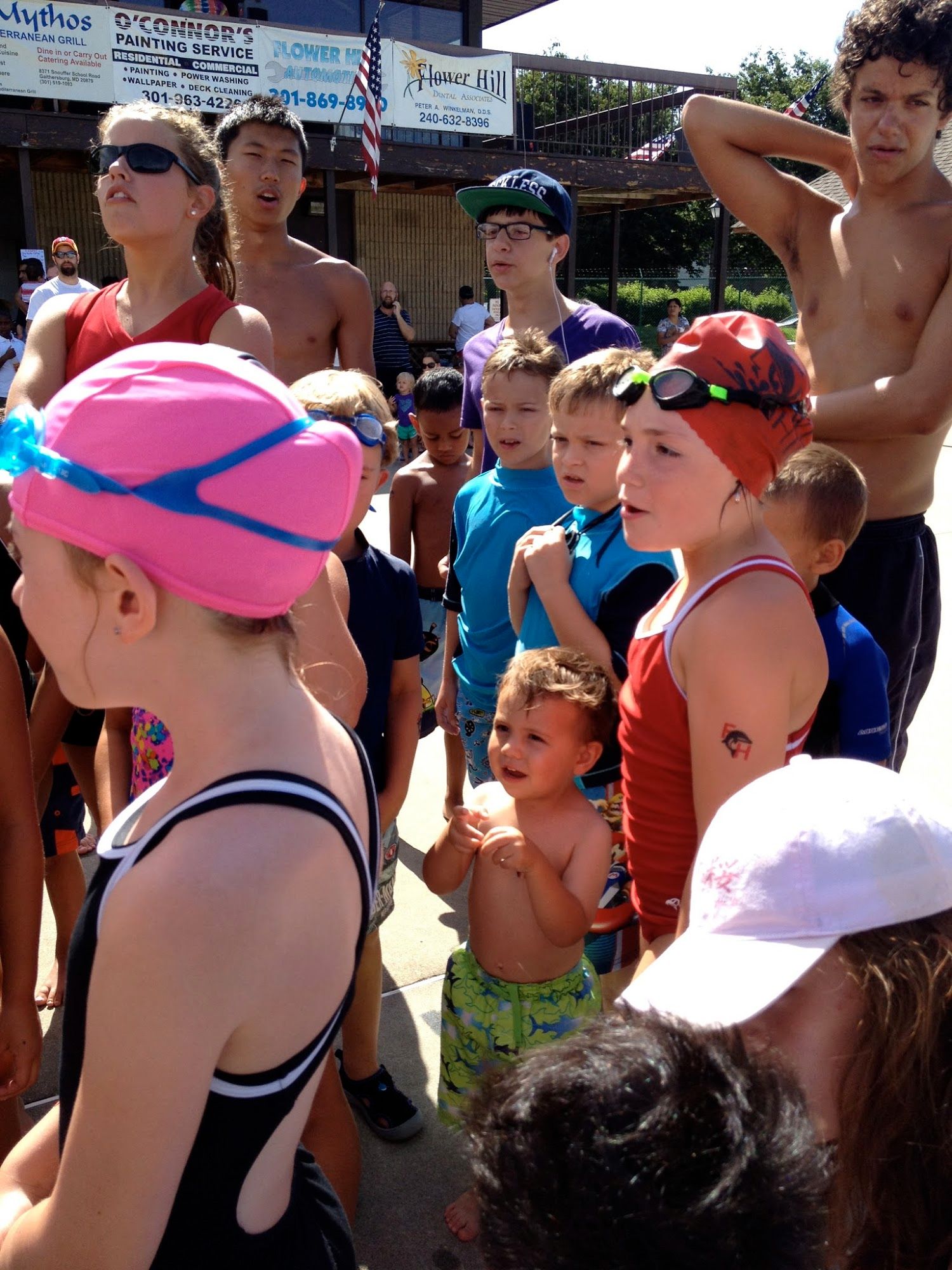  Gotta love swim team. The only sport where it is multi-aged, co-ed, a team competition, and where you also compete against yourself.  There's Bananas in the middle doing a cheer with the big team. 