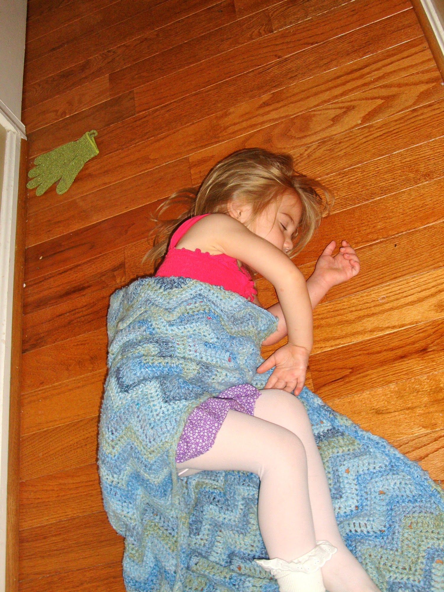  Same day as above picture. I had taken her to her room only to find her later asleep on the hard wood floor in our front hall. She took the time to put on tights and frilly socks before falling asleep again. 